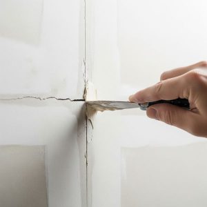 Close-up of a small drywall crack being repaired.