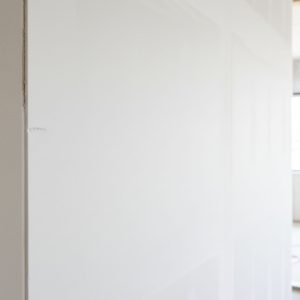 Close-up of a perfectly smooth, white standard drywall surface in a new interior space.